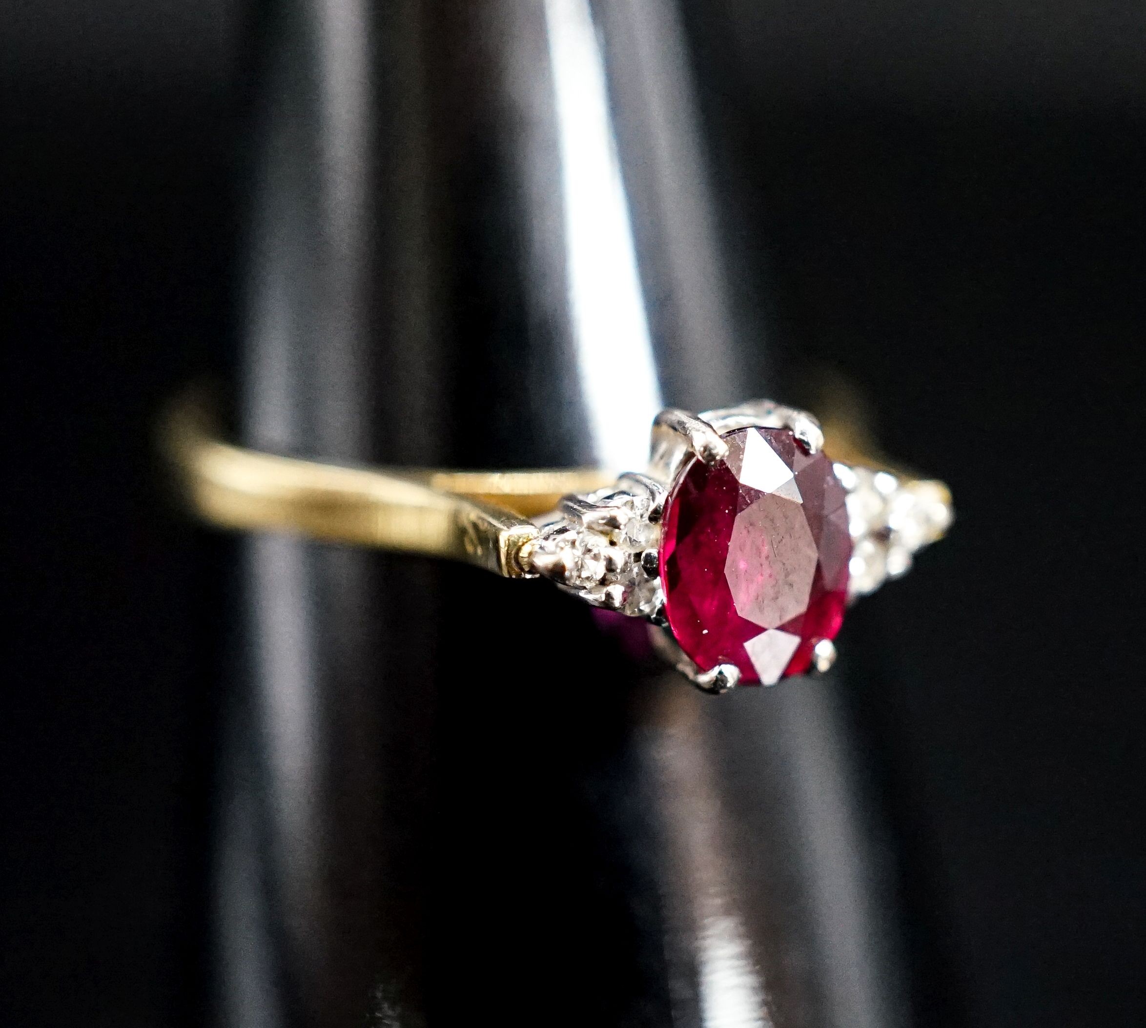 A 750 yellow metal, single stone oval cut ruby and six stone diamond chip set ring, size O, gross weight 2.7 rams.